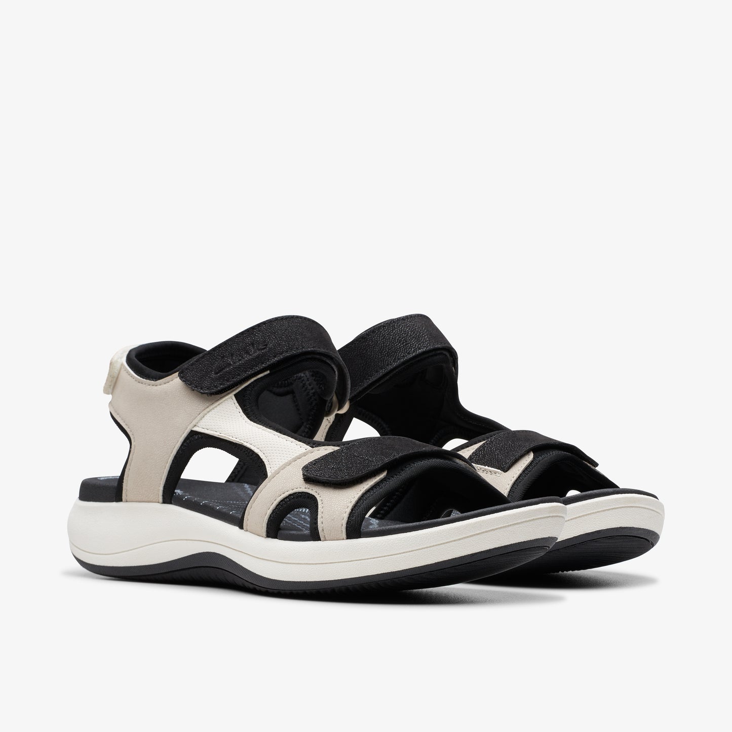 Pair of beige and black sandals with velcro straps.