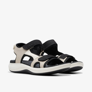 Pair of beige and black sandals with velcro straps.