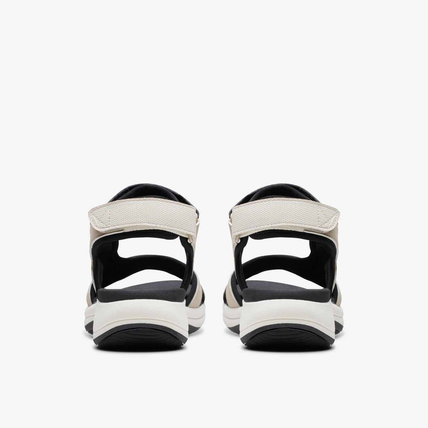 Pair of sandals with black soles and white straps.