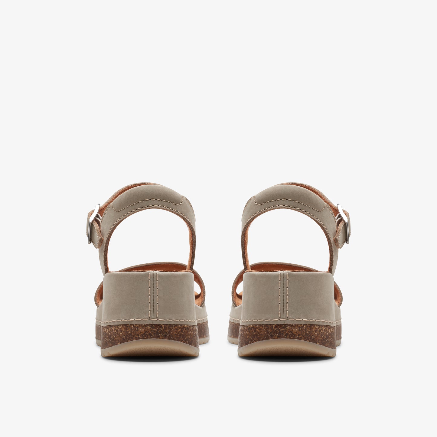 Pair of low heel, beige sandals with a buckled ankle strap, viewed from the back.