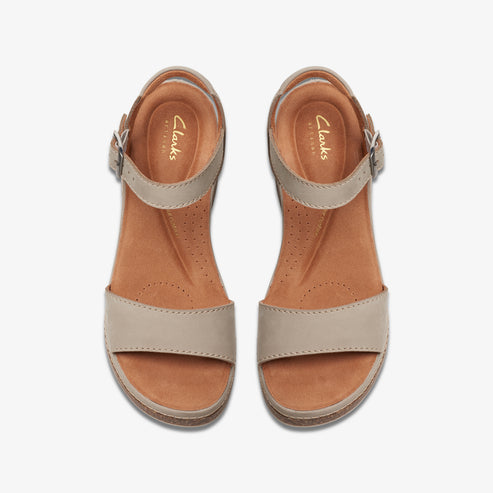 Top-down view of two beige-colored Clarks sandals, each with a buckled ankle strap and wide toe strap.