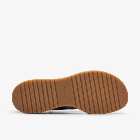 Close-up of a shoe sole with brown horizontal ridged patterns and the text "Clarks".