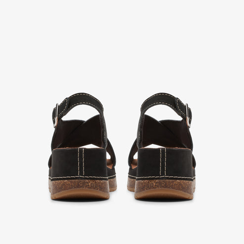 Back view of a pair of black sandals with adjustable ankle straps and white stitching along the midsoles.