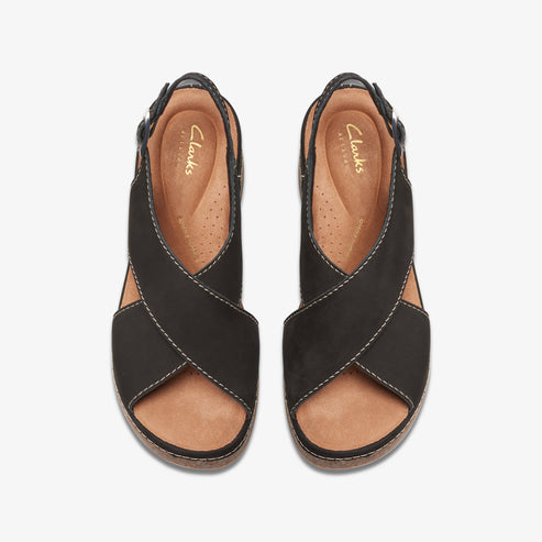 Overhead view of black open-toe sandals with crossing straps.