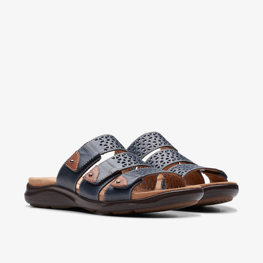 Pair of navy blue sandals with punched-out designs, straps and low brown soles.