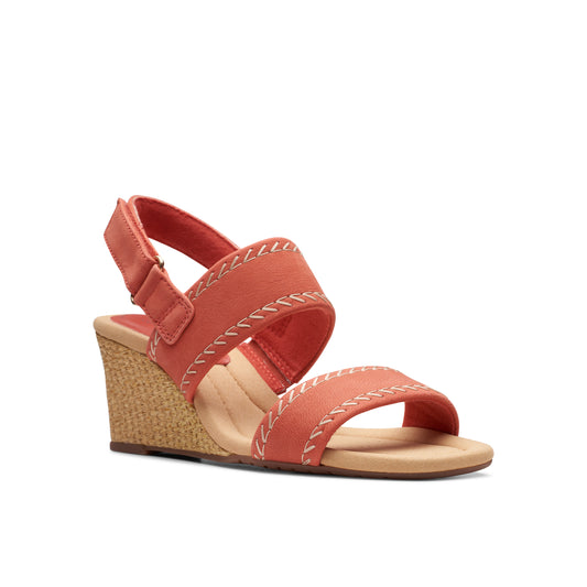 Coral sandal with a wedged heel and ankle strap.