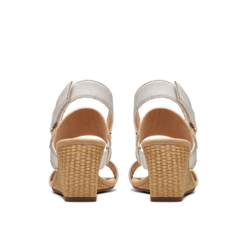 Pair of wedge sandals with velcro straps and woven heels, viewed from the back.