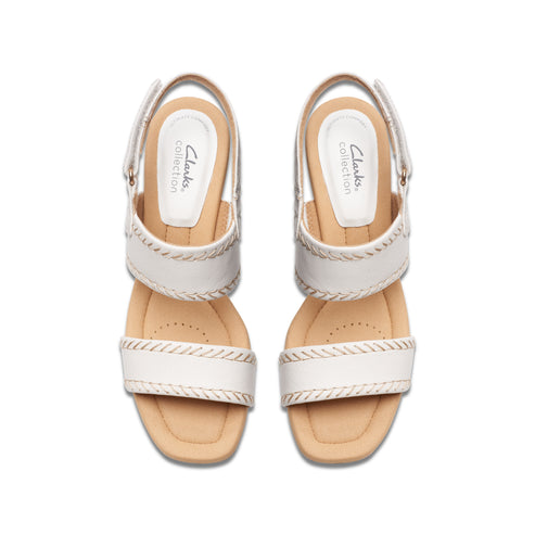 Pair of white sandals with thick straps and low heels, view from above.