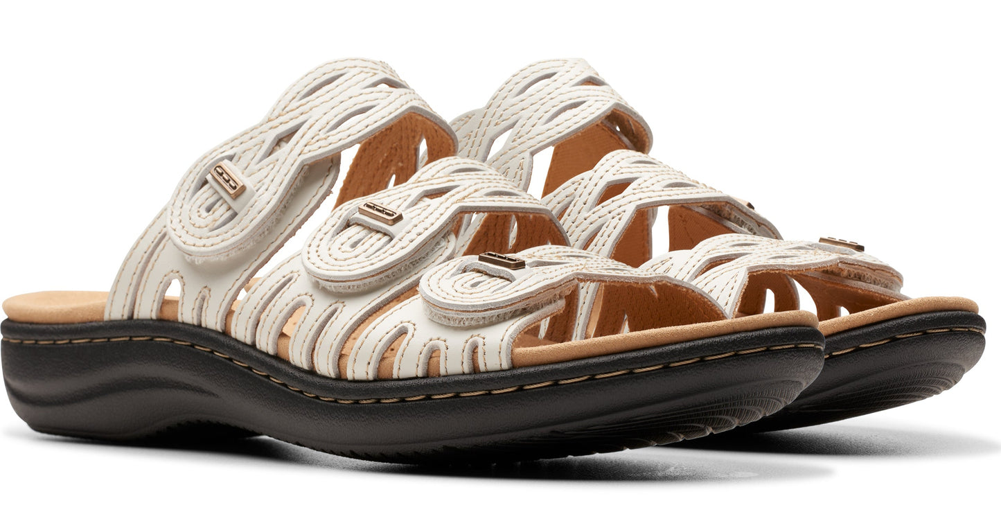 Pair of off-white slide sandals with interwoven straps and adjustable velcro closures.