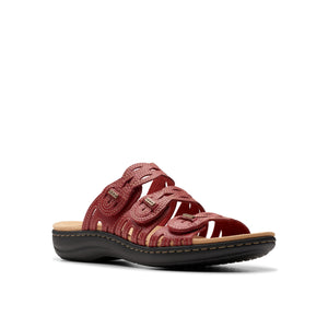 Red leather sandal with circular, woven detailing and a black sole.