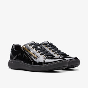 Pair of black patent leather sneakers with a gold zipper accent.