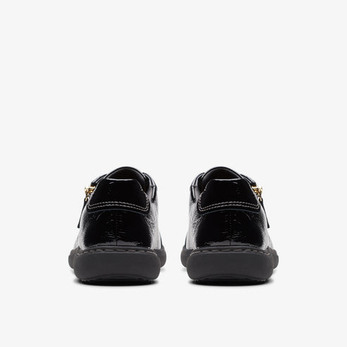 Back view of shiny black sneakers with gold zippers.