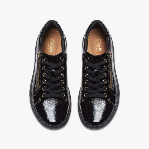Top-down view of a pair of shiny black lace-up sneakers with gold zippers.