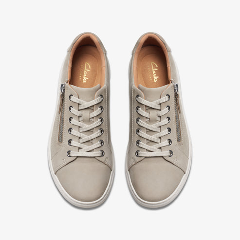 Overhead shot of two identical sneakers: gray, lace-up, rounded toe, side zipper, "Clarks" imprinted on the tan insole.