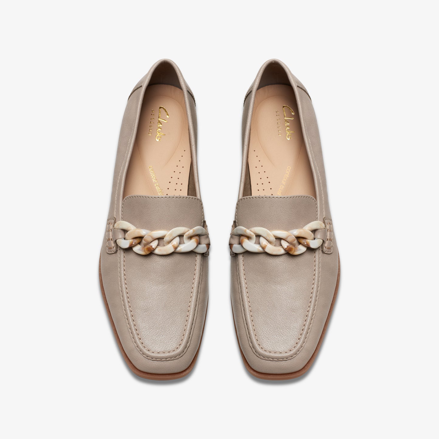 Pair of loafer shoes in light taupe with white chain detail.