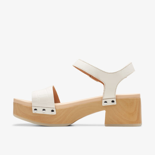 White sandal with ankle strap and block heel.