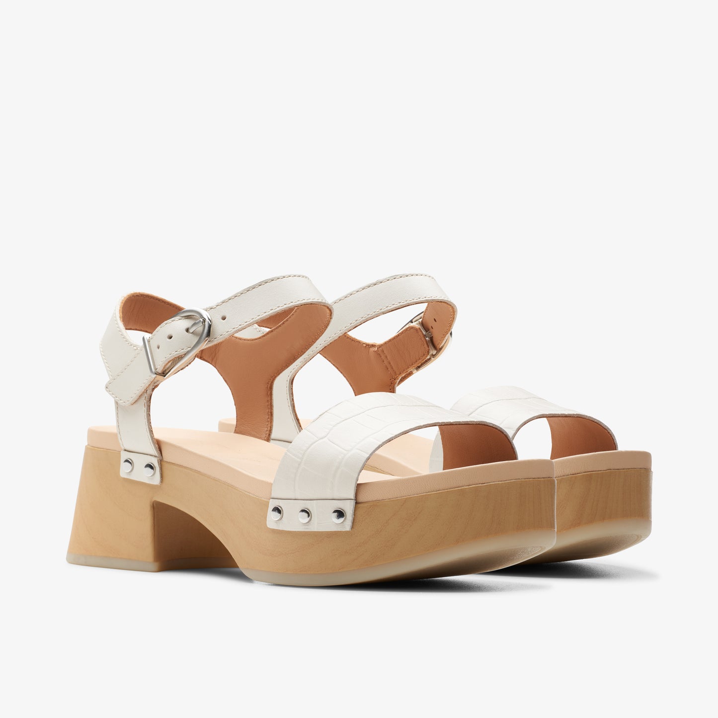 White heeled sandals with thick, light-brown soles and adjustable straps