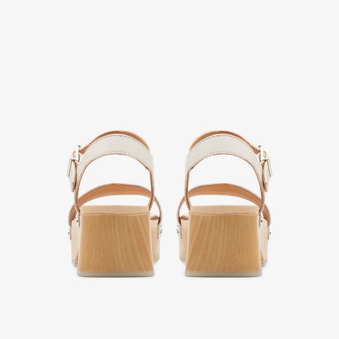 Back view of two high heel sandals with beige straps and light wooden block heels.