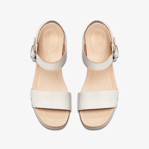 Overhead view of two white sandals with buckled straps and textured bands.
