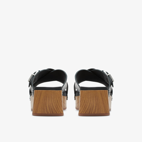 Back view of black platform sandals with adjustable straps and light-brown block heels.