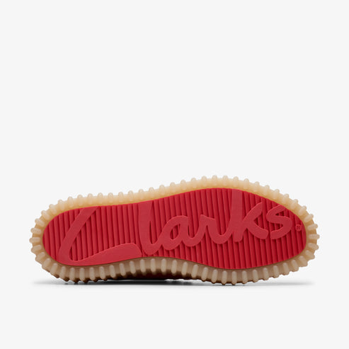 A shoe's red and tan sole with 'Clarks' written in red script.