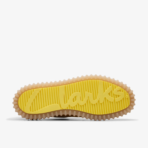 Shoe sole with yellow logo spelling Clarks on the yellow shoe bed and beige surrounding edges.