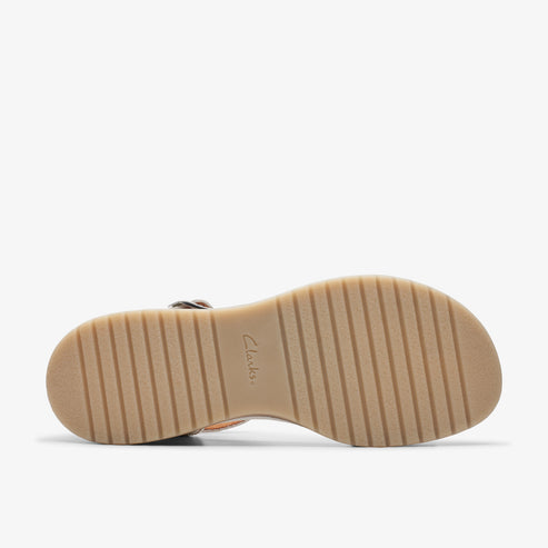 A sandal from the bottom view showing a light brown sole with lines of tread.