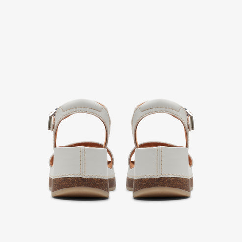 Pair of white sandals with adjustable buckle strap and cork soles.