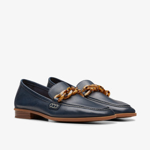 Pair of navy blue leather loafers with a brown tortoiseshell chain.