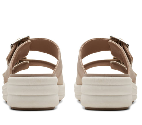 Pair of tan platform sandals with double straps and silver buckles, viewed from the back.
