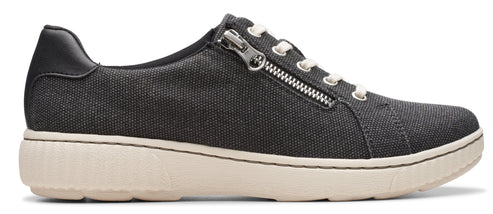 A low top gray sneaker with a white sole and laces and a zipper detail.
