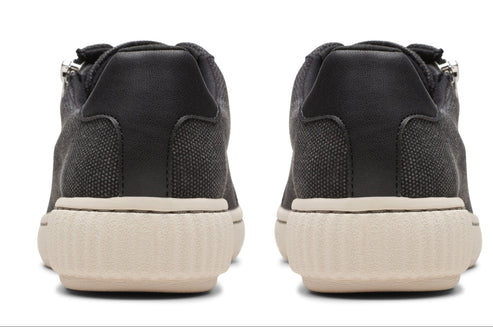 Back view of a pair of gray canvas sneakers with off-white soles.