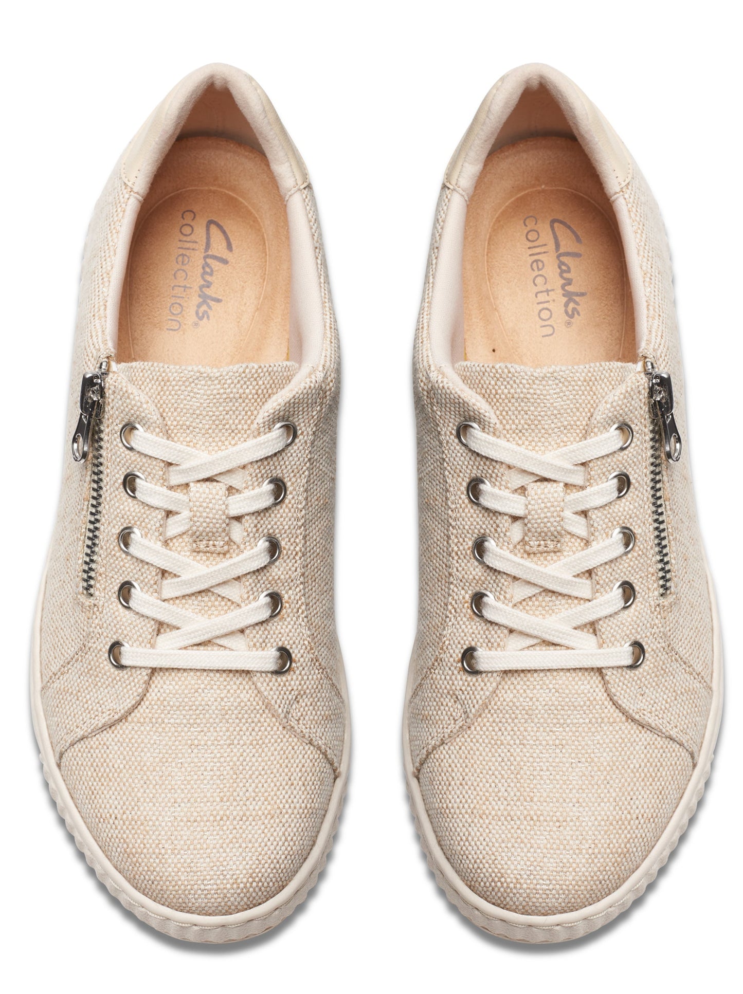 Top-down shot of beige canvas sneakers with laces and side zippers.