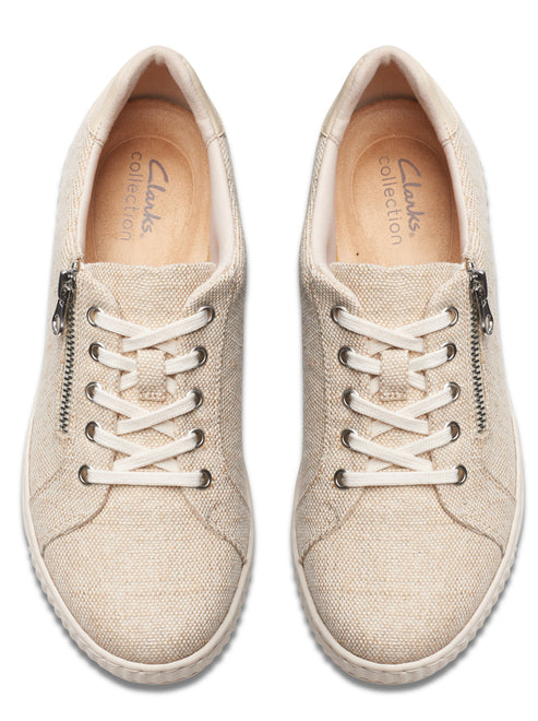 Top-down shot of beige canvas sneakers with laces and side zippers.