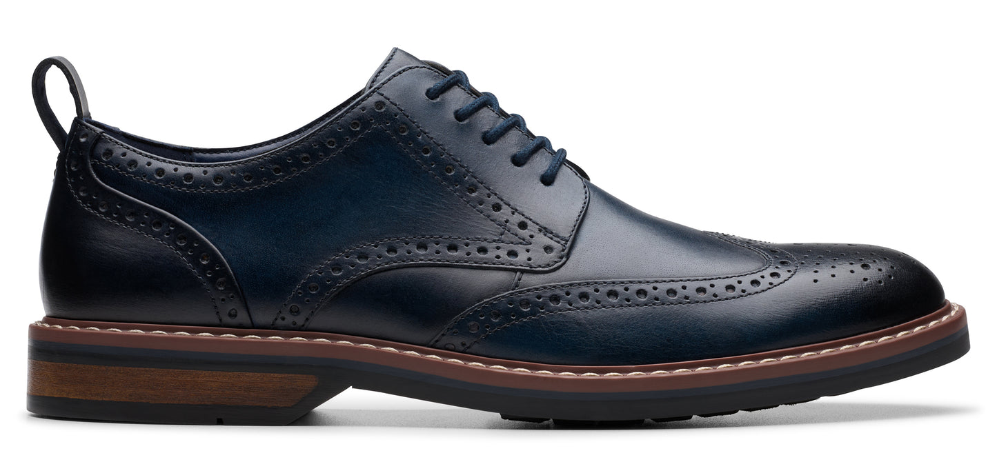 A blue leather lace-up wingtip dress shoe with a pull tab on the heel.