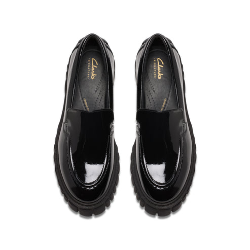 Top-down view of shiny black loafers with thick, textured soles.