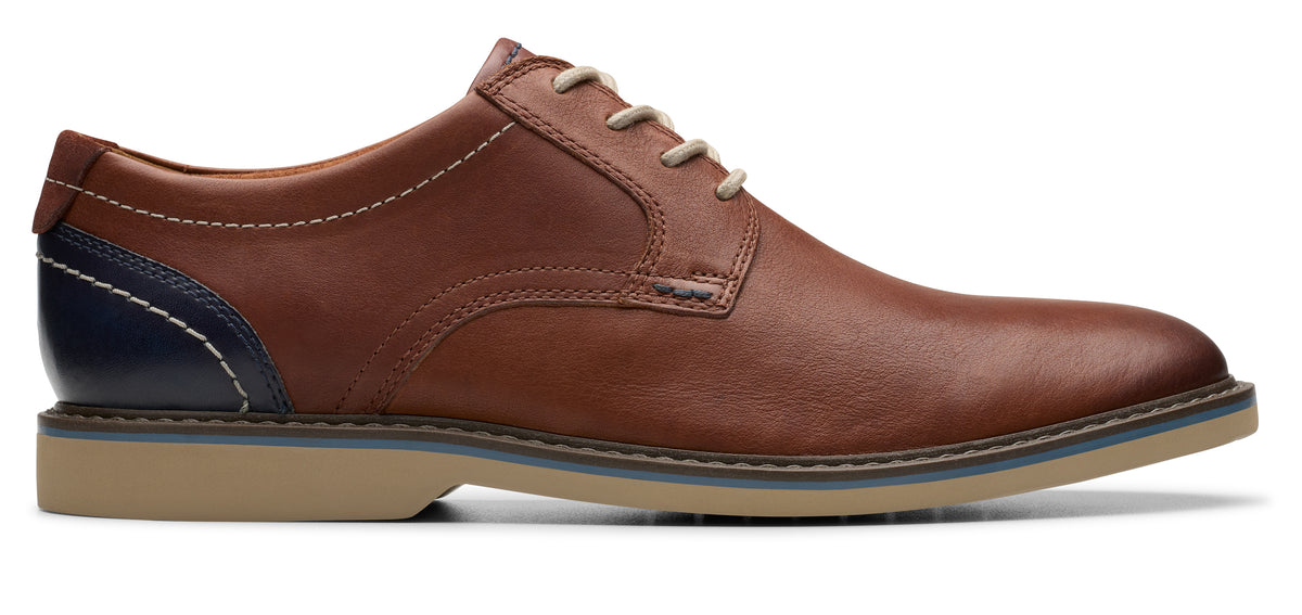 A brown leather oxford dress shoe with light colored laces.