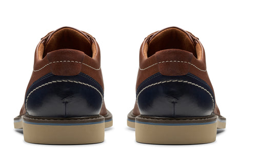 Back view of two brown and navy shoes with stitching and light-colored soles.