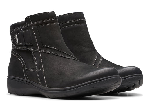 Pair of black ankle boots with decorative white stitching and side buckle.