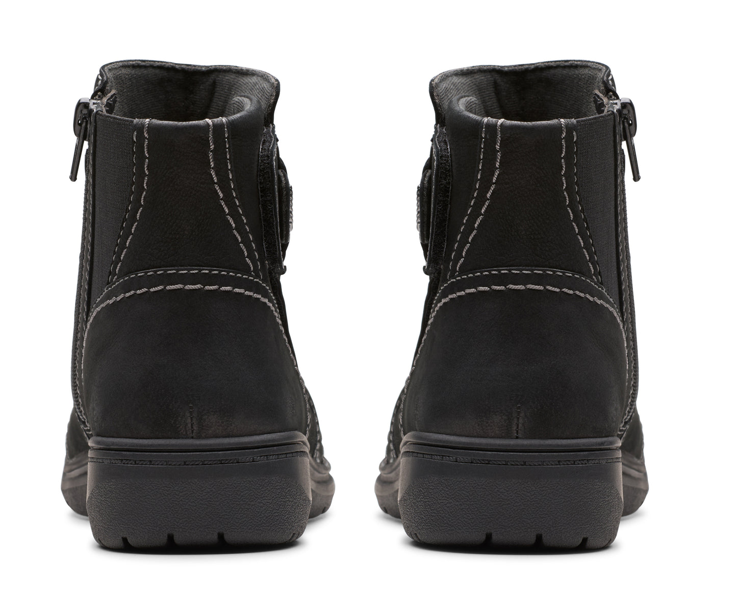 Pair of black ankle boots with zippers, seen from the back.