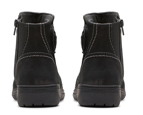 Pair of black ankle boots with zippers, seen from the back.