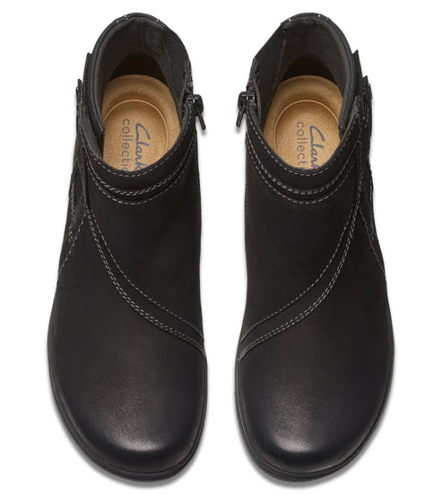 Pair of ankle boots, black leather, decorative stitching, side zipper, top-down view.