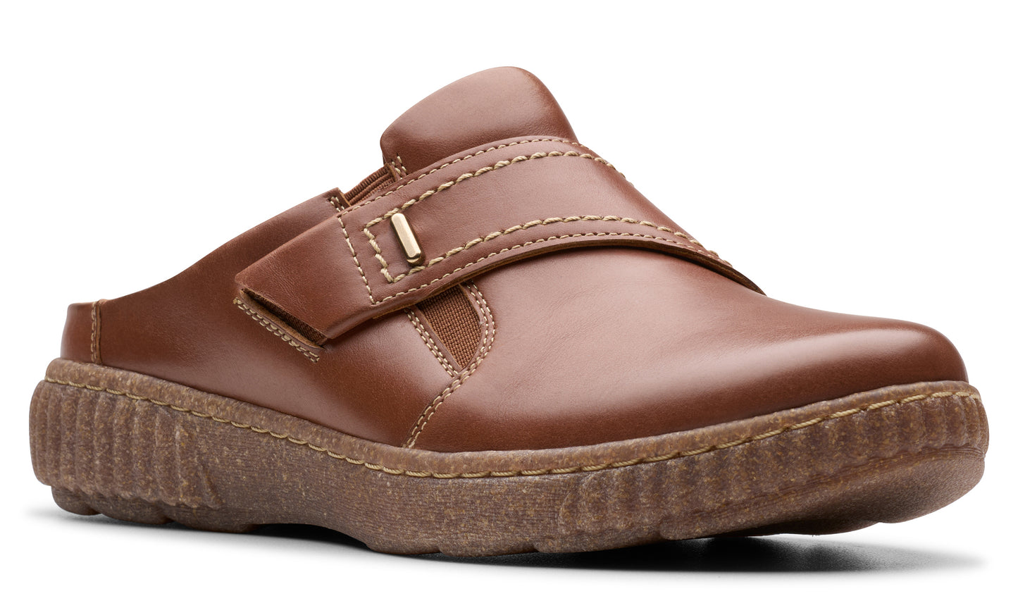 Brown slip-on shoe with adjustable hook-and-loop strap and treaded sole.