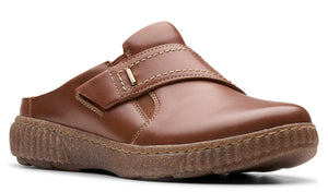 Brown slip-on shoe with adjustable hook-and-loop strap and treaded sole.