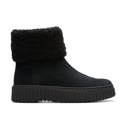 A black suede boot with a fluffy black cuff and thick black sole.