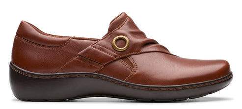 A brown leather slip-on shoe with a low heel and a decorative gold ring detail.