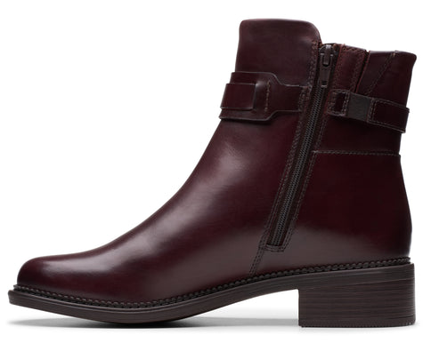 Burgundy ankle boot with block heel and decorative buckle.