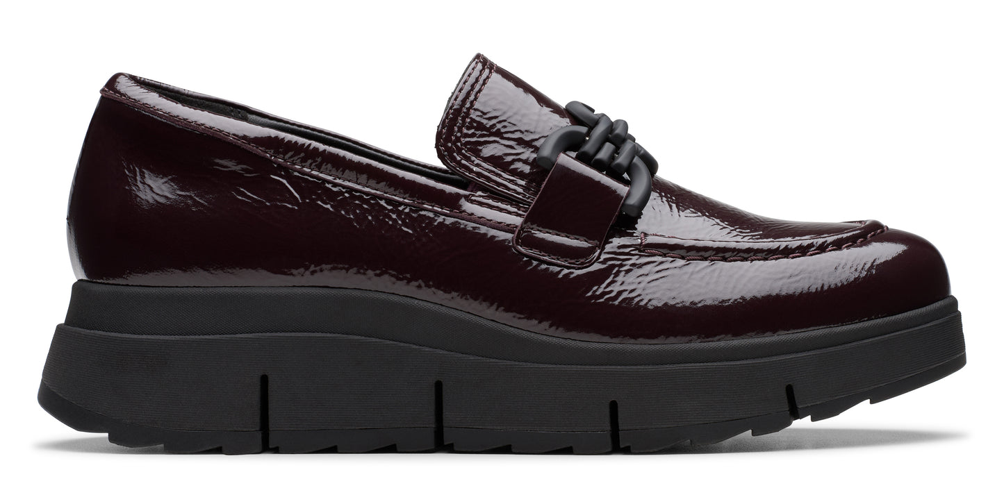 A patent leather, burgundy loafer with a thick black sole.