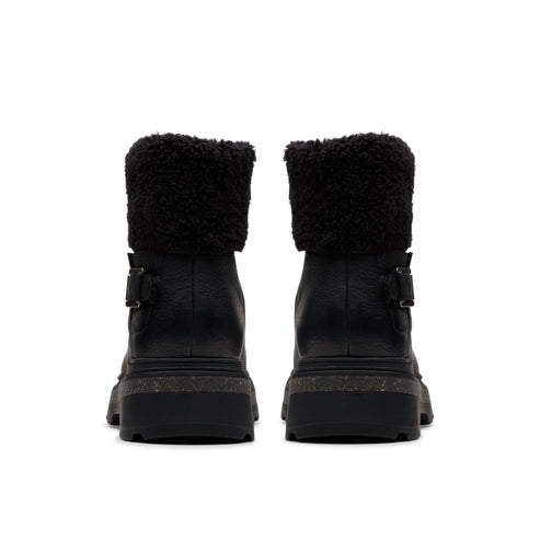 Two black, heeled, combat boots with black fluffy collars facing forward.