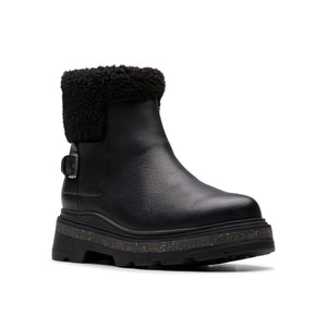 Black leather ankle boot with a black faux-fur collar and buckle detail, atop a chunky lug sole.